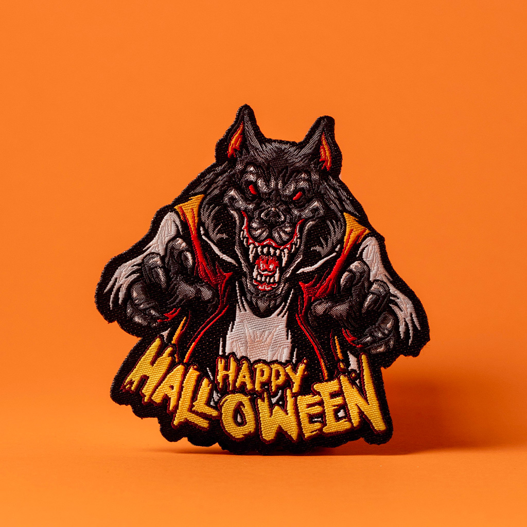 Halloween-Wolfsaufnäher mit feurigen Augen auf orangefarbenem Hintergrund.