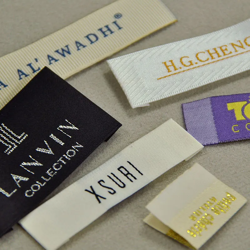 Kleideretiketten Mit Logo: Welches Druckverfahren? 3 Kleideretiketten mit Logo als Beispiel für Textiletiketten-Herstellung mit Hängeetikett, Größenetikett und Aufnäheranwendung